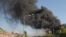 Armenia -- Onlookers watch as black smoke billows from the Nairit chemical plant in Yerevan hit by an explosion on 14May2009