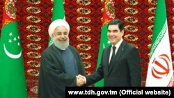 Президент Туркменистана Гурбангулы Бердымухамедов (слева) приветствует президента Ирана Хасана Роухани (справа).