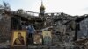 A woman collects Orthodox icons at the site of a church destroyed by a Russian missile strike in the village of Komyshuvakha on April 16.
