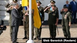 Президент України Петро Порошенко (л) під час церемонії підняття прапора на Софійській площі в Києві, 23 серпня 2017 року