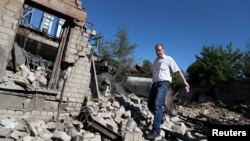 Чоловік біля зруйнованого російськими обстрілами будинку в Харкові, 7 червня 2022 року