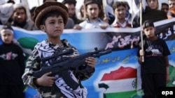 Пакистанда тыюу салынган "Жамаат-уд-Дава" соопкерчилик уюмунун колдогон бала Кашмирдин Индия бөлүгүндө жашаган кашмирликтерди колдогон митингде оюнчук автомат кармап турат. Пешавар, 5-февраль 2015