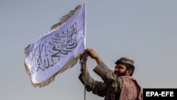 Ооганстан. "Талибан" кыймылынын өкүлү мамлекеттик тууну алып салып, өзүнүн желегин илип жаткан учур. Кандагар. 17-август, 2021-жыл.