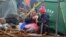 A migrant and her children rest beside a tent in Belarus's Hrodno region, near the Polish border, on November 10. 