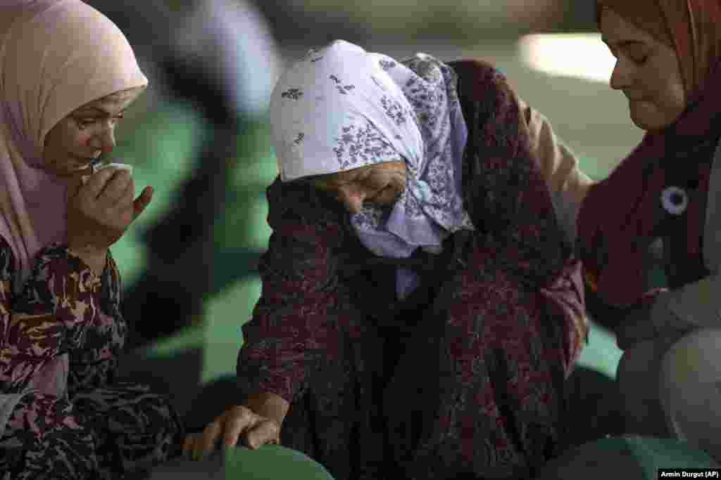 Нума Яхич скорбит у гроба с останками ее сына, которого опознали только в этом году в&nbsp;Сребренице в Потокари. Босния, 10 июля 2022 года. Тысячи людей собрались в восточном боснийском городе Сребреница, чтобы отметить 27-ю годовщину единственного признананного геноцида в Европе со времен Второй мировой войны. (AP Photo/Армин Дургут)