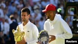Новак Жокович менен Ник Кирьос Уимблдон турниринин сыйлыктарын кармап турушат.