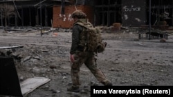 Український військовослужбовець проходить повз будівлю, пошкоджену російськими військовими ударами, в місті Покровськ Донецької області