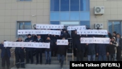 Techno Trading LTD жұмысшылары аштық акциясында президент Нұрсұлтан Назарбаевтан құқықтарының бұзылуына жол бермеуге шақырған плакат ұстап тұр. Маңғыстау, 5 қаңтар 2017 жыл.  