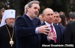 Голова Спілки художників Росії Андрій Ковальчук і президент Росії Володимир Путін (зліва направо на передньому плані) та митрополит Сімферопольський і Кримський УПЦ (МП) Лазар (зліва на задньому плані) під час церемонії відкриття пам’ятника імператору Олександру III в парку Лівадійського палацу. Окупована Ялта, 18 листопада 2017 року