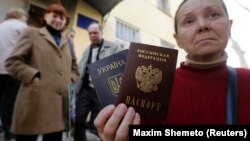 Окупований Крим. Жінка тримає український і російський паспорти біля офісу Федеральної міграційної служби Росії, де вона отримала російський паспорт від окупаційної влади. Сімферополь 7 квітня 2014 року