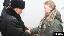 Офицер полиции надевает наручники на осужденную на два года тюрьмы Елизавету Дреничеву. Алматы, 9 января 2009 года.  