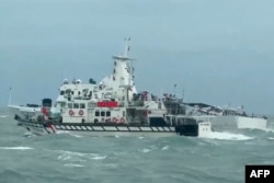 Судно береговой охраны Тайваня (на переднем плане) и судно Береговой охраны Китая (на заднем плане) в водах у островов Мацзу в Тайване, во время китайских учений по отработке блокады острова