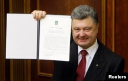 Президент Петро Порошенко демонструє підписаний закон про ратифікацію Угоди про асоціацію з Євросоюзом Президент Петро Порошенко демонструє підписаний закон про ратифікацію Угоди про асоціацію з Євросоюзом