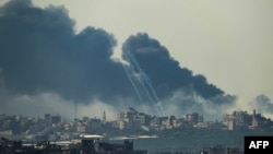 Gaza zolagynda ysraýyl zarbalary tarapyndan urlan binalardan tüsse asmana göterilýär. 1-nji dekabr, 2023 ý. 