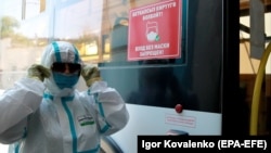 Сотрудник троллейбусной автотранспортной компании распыляет дезинфицирующее средство внутри троллейбуса в Бишкеке. 14 июня 2021 года. 