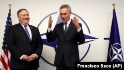 Государственный секретарь США Майк Помпео (слева) и генеральный секретарь НАТО Йенс Столтенберг  беседуют перед встречей с министрами в штаб-квартире НАТО в Брюсселе, 4 декабря 2018 года.
