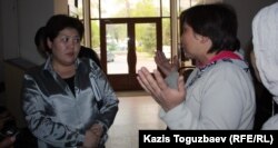 Назгуль Смагулова (слева), начальник отдела социальной сферы акимата Турксибского района Алматы, говорит с погорельцами.