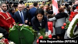 Грузиянын президенти Саломе Зурабишвили 9-апрель окуяларынын курмандыктарына гүл коюп жаткан учуру.