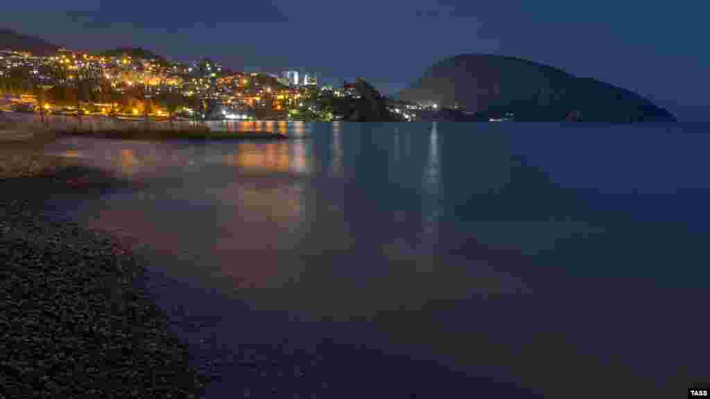 Вночі вогні перетворюються на один великий клубок світла. У тіні залишається лише Ведмідь-гора (Аю-Даг)