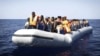 Нелегальных мигрантов из Африки перевозят на спасательных лодках итальянских ВМС после крушения корабля, на котором они находились. Средиземное море, сентябрь 2014 года.  