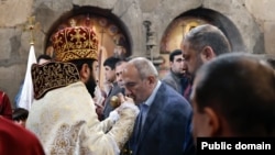 Armenia - Prime Minister Nikol Pashinian kisses a cross held by defrocked priest Stepan Asatrian during a ceremony at Hovanavank monastery, October 26, 2025.