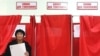 Russia -- A woman leaves a voting booth at a polling station in Stavropol, 02Dec2007