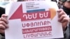 Armenia - A demonstrator in Yerevan holds a poster objecting to government plans to close the Ministry of Diaspora, December 25, 2018.