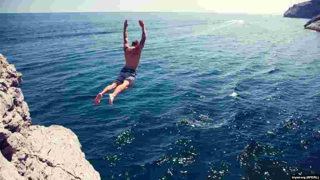 Чоловік стрибає в море з валуна в Новому Світі біля Судака