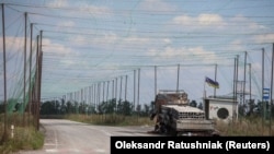 Спалений автомобіль та антидронові сітки над дорогою поблизу Добропілля, Донецька область, 10 серпня 2025 року