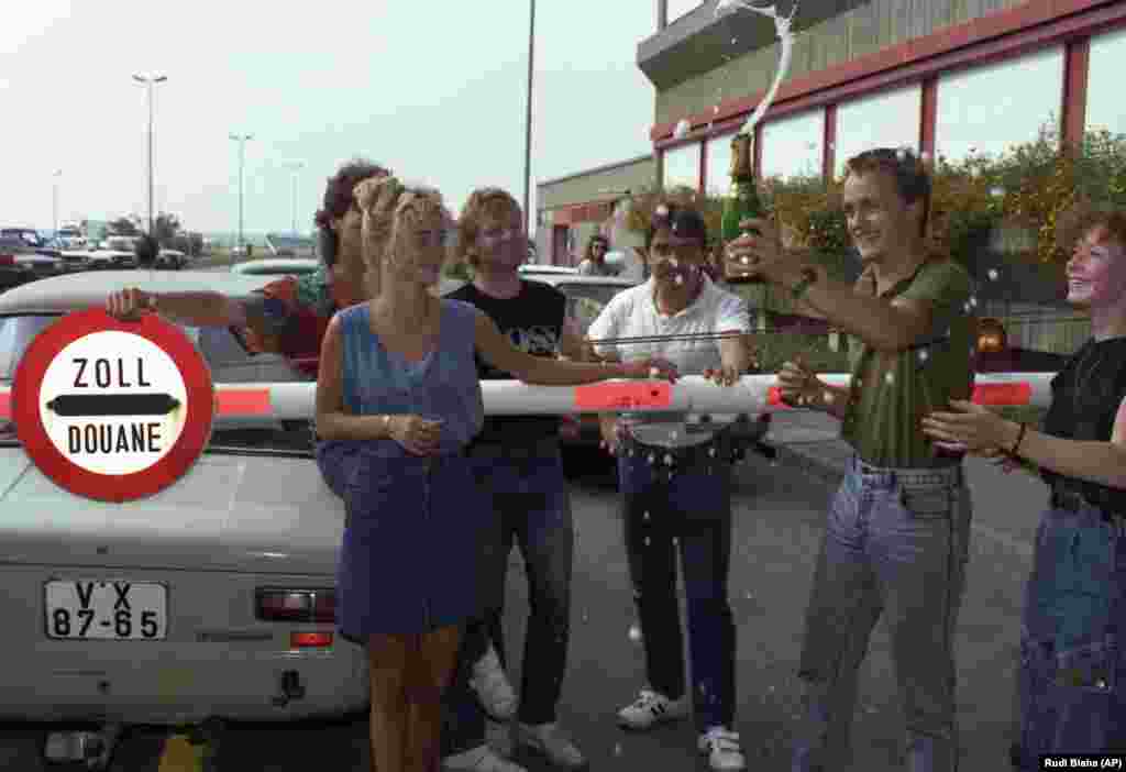 Others celebrate with a bottle of sparkling wine at the customs gate.