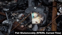 Обгоревший паспорт одного из пассажиров рейса MH17 на месте трагедии под Донецком, июль 2014 года