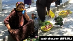 Aşgabadyň köçeleriniň birinde gök-bakja önümlerini satýan ene.
