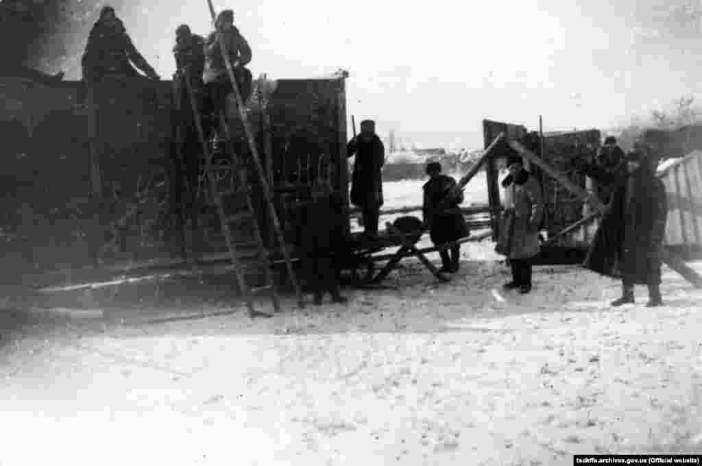 Чоловіки забирають майно у розкуркуленого селянина, Червоноармійський район Донецької області, 1930-і роки