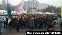 Гражданские активисты несут цветы к мемориалу, посвященному Декабрьским событиям. Алматы, 17 декабря 2010 года.