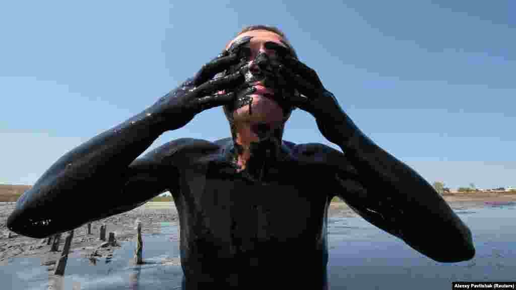 Чоловік намазує себе лікувальною гряззю у водах озера Чокрак, що біля села Курортне під Керчю