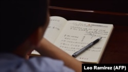 Донишҷӯе суханронии Си Ҷинпинро ёддошт мегирад. Акс аз як муассисаи таълимии Чин, соли 2019