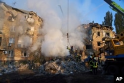 Пожарные тушат пожар в здании после российского удара по Киеву, Украина, 28 августа 2025 года