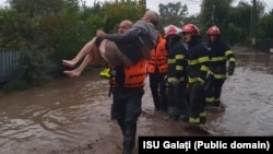 Emergency workers evacuate a resident of Glati county in Romania's eastern Moldova region on September 13.