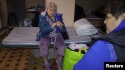 13-nji oktýabrda giçlik Russiýanyň Harkow şäherine eden howa hüjümi wagtynda hassalar ýerzeminde pena gözleýärler. 