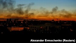 Дим над будівлями під час заходу сонця в час боїв неподалік лінії фронту. Окупований Донецьк, 7 серпня 2022 року