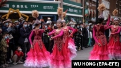 Үрүмчүдөгү базарда бийлеп жаткан кыздар. Шинжаң, Кытай. 