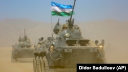Uzbek armored personnel carriers roll during joint military drills by Russia, Tajikistan, and Uzbekistan near the Tajik border with Afghanistan on August 10.