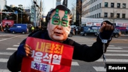 Участник акции протеста с требованием импичмента президента Юн Сок Ёля