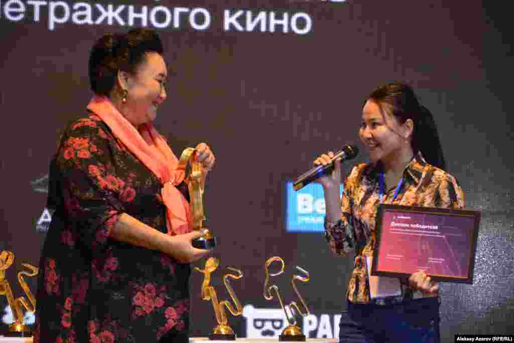 Кымбат Тойшы (справа) получает из рук Гульнары Абикеевой приз в номинации &laquo;Лучший документальный фильм&raquo; за работу &laquo;Ауыл тынысы&raquo; (&laquo;Дыхание аула&raquo;), рассказывающую о семье фермера.