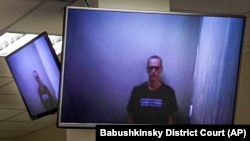Russian opposition leader Aleksei Navalny appears on TV screens via a video link from prison during a court hearing in Moscow on April 29.