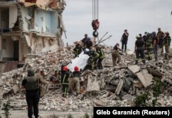 Спасатели извлекают тело из завалов, город Часов Яр в Донецкой области, 10 июля 2022 года