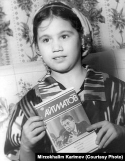 Тажик кызы Жамила Айтматовдун китебин кармап турат.