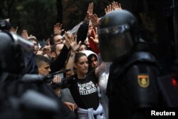 Демонстранты и полиция на улицах Барселоны в день признанного незаконным референдума о независимости Каталонии 1 октября