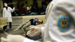 Медики в Ухані поруч з пацієнтом, який втратив свідомість і який, ймовірно, заразився атиповою пневмонією (захворювання відоме як SARS – тяжкий гострий респіраторний синдром)