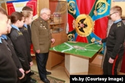 Віктар Пенза вядзе заняткі зь берасьцейскімі кадэтамі. На сьцяне вісіць адноўленая харугва часоў Расейскай імпэрыі.